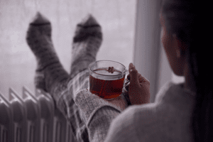 A person relaxes on a chilly day. 6 Ways Your Furnace Keeps You Safe.